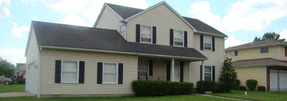 A two-story house with a grey roof and white siding.