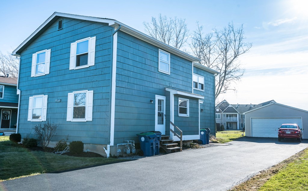 a blue house with a car parked in front of it