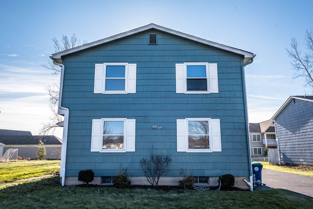 a blue house with white windows on a sunny day