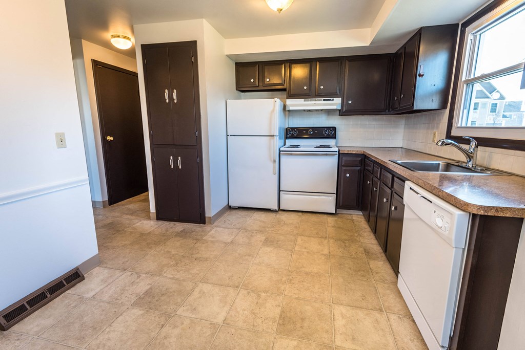 a kitchen with white appliances and black cabinets