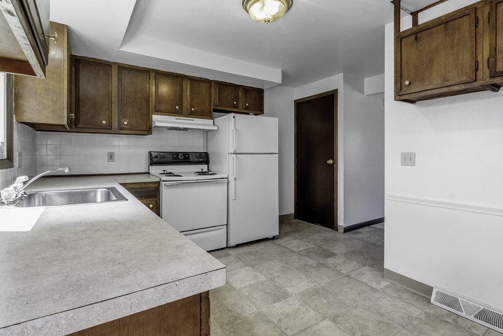 a kitchen with white appliances and wooden cabinets