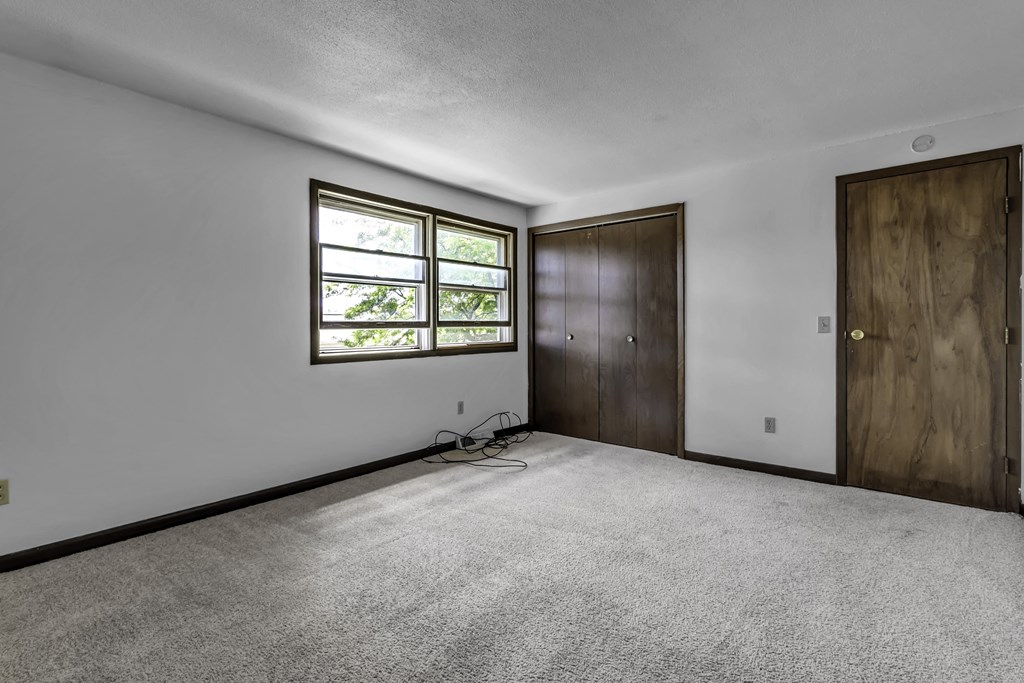 an empty room with white walls and a window and a door