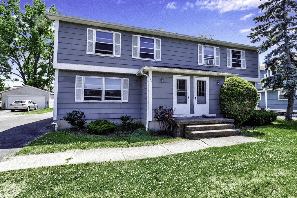 a blue house with a sidewalk in front of it
