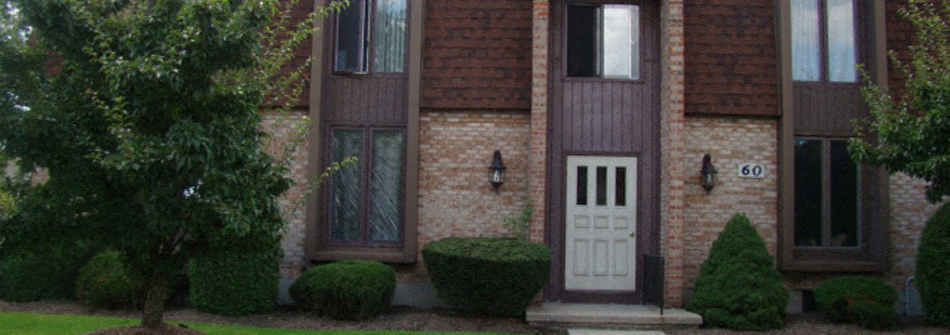 A brown house with a white door and windows.