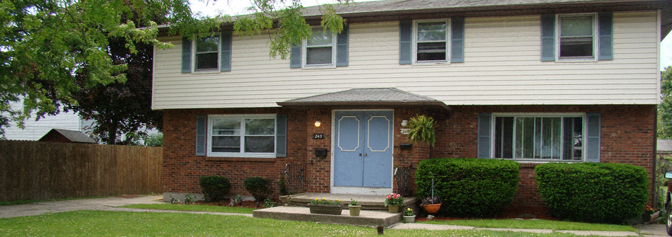 A house with a blue door and a grey roof.