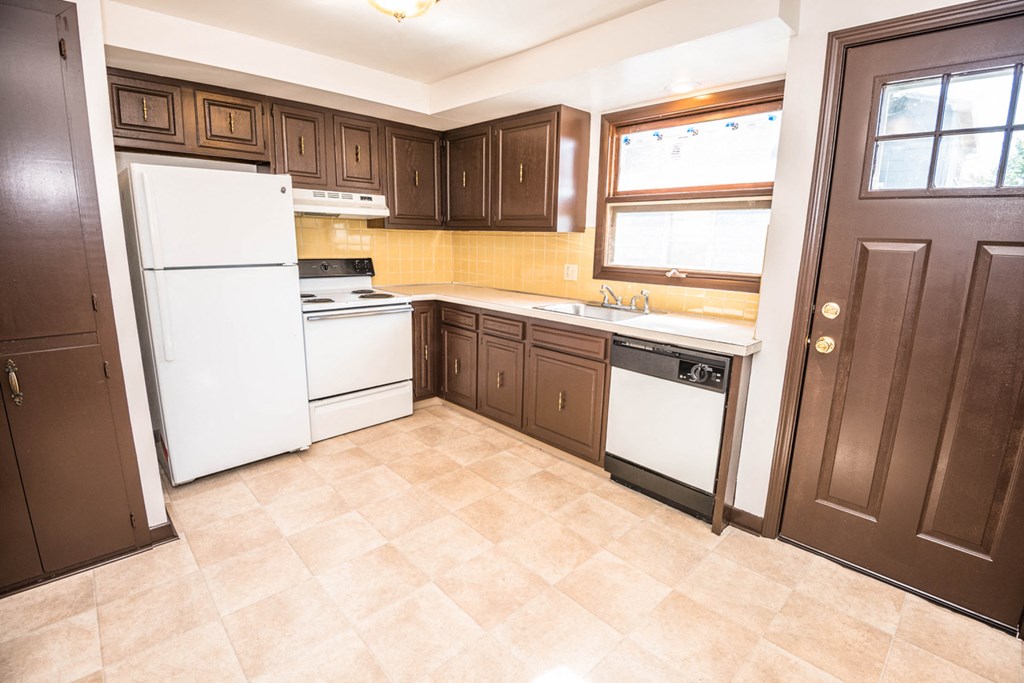 a kitchen with white appliances and brown cabinets