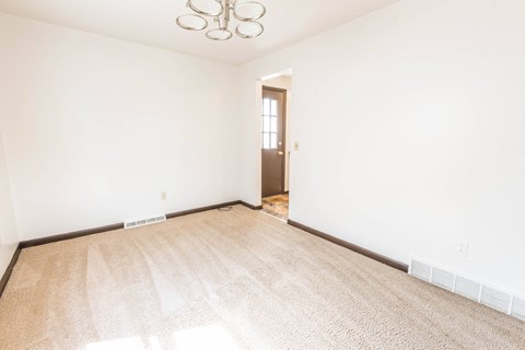 a living room with a rug and white walls