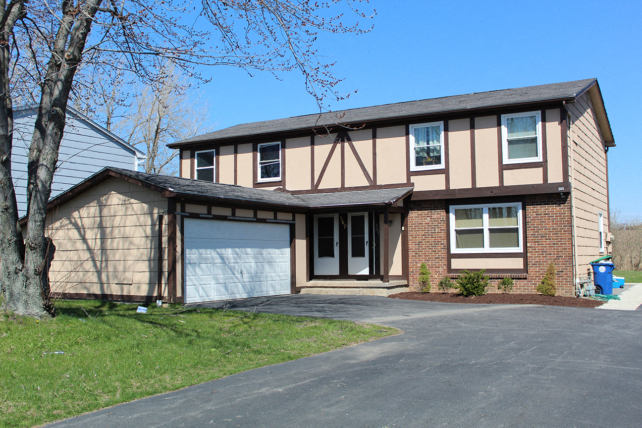 a tan and brown house with a garage door