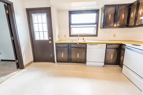 a kitchen with wooden cabinets and a white dishwasher