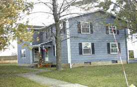 a blue house with a tree in front of it