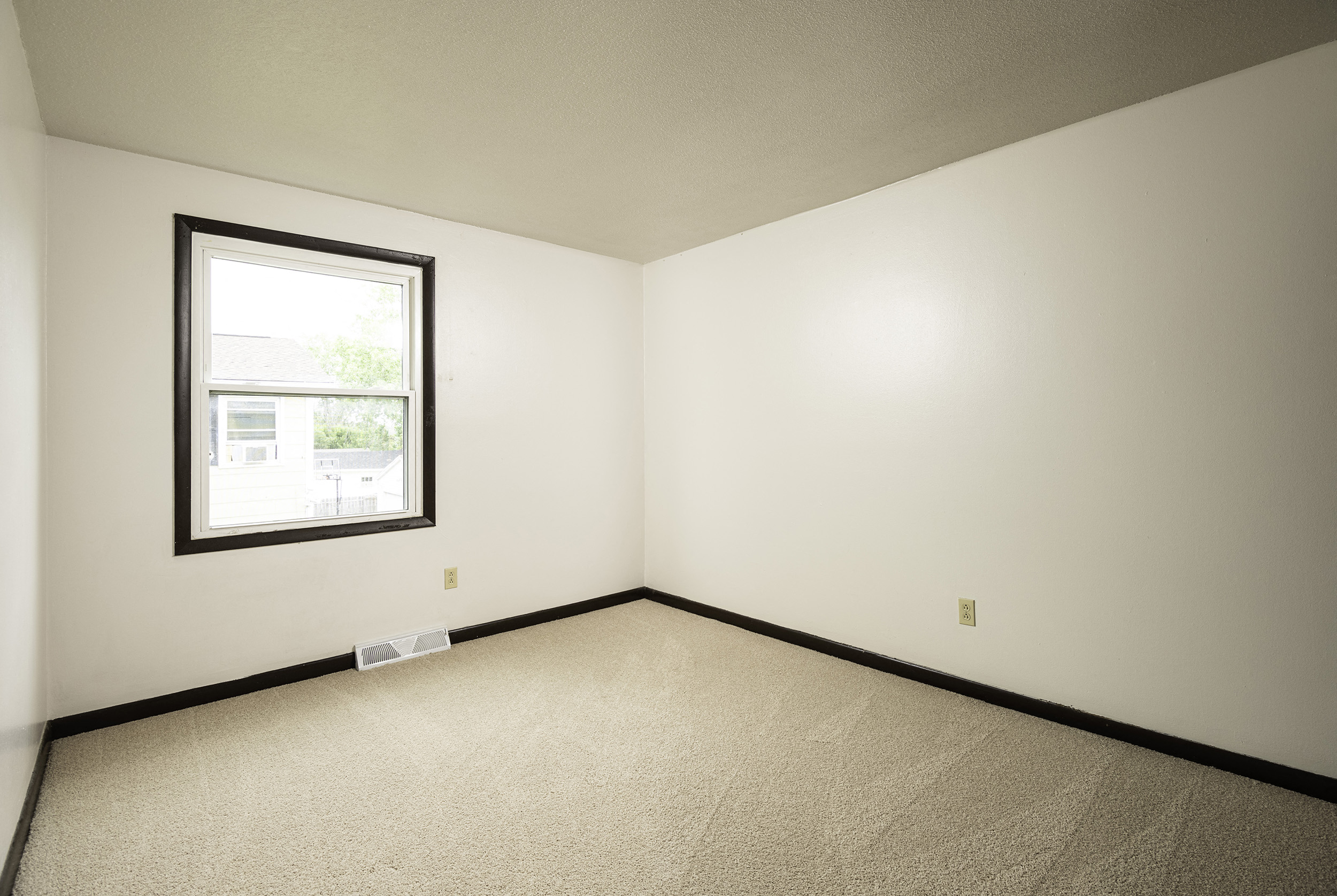 an empty room with a window in the corner