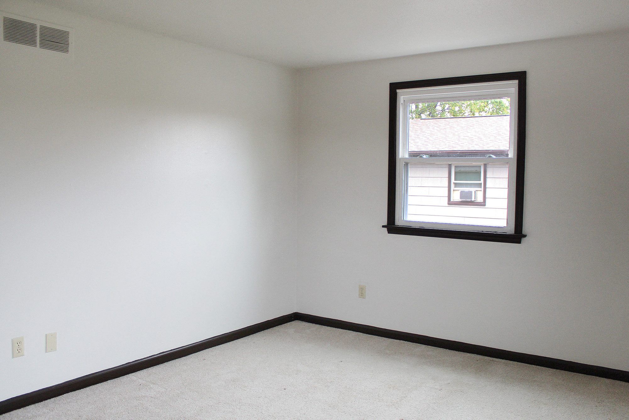 a bedroom with a window and white walls