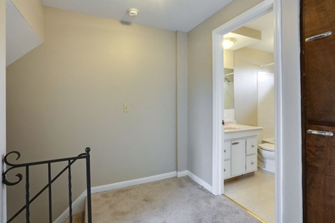 a bedroom with a staircase and a bathroom with a toilet and sink