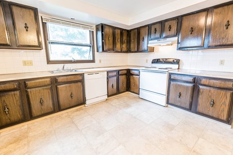 a kitchen with wooden cabinets and white appliances