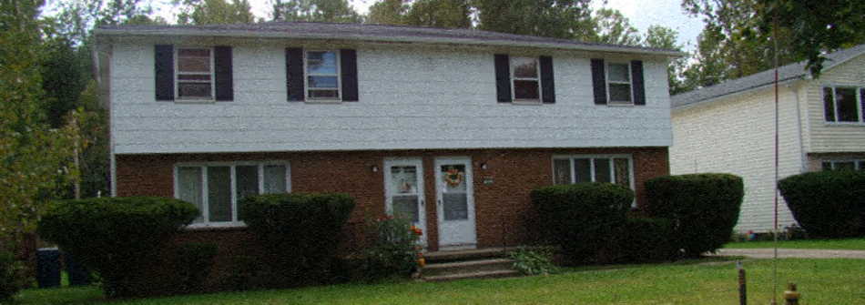A white house with a red door and a small porch.