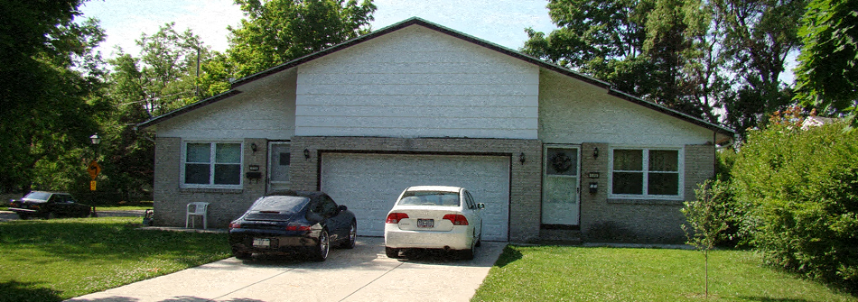 a house with two cars parked in front of it