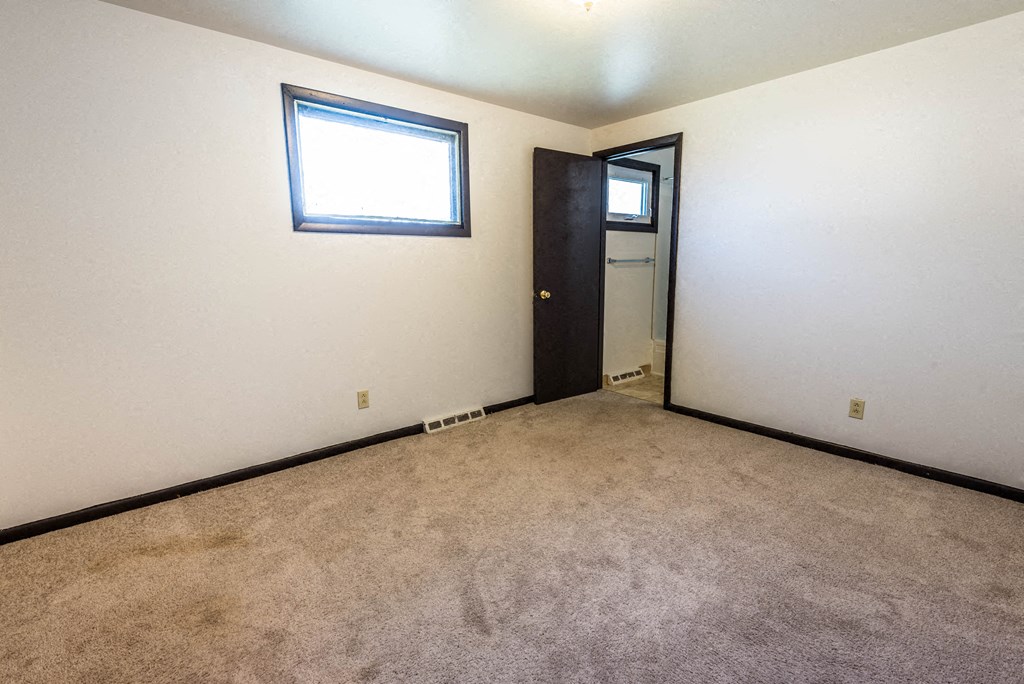 a room with a carpeted floor and a door to a closet