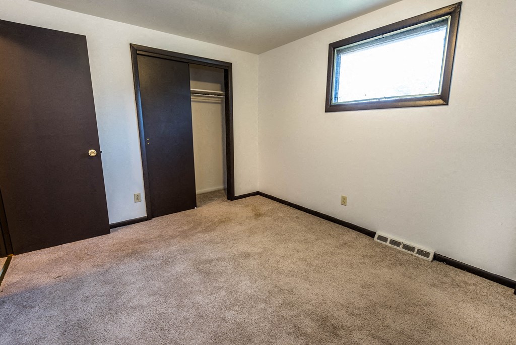 a room with a carpet and a door and a window