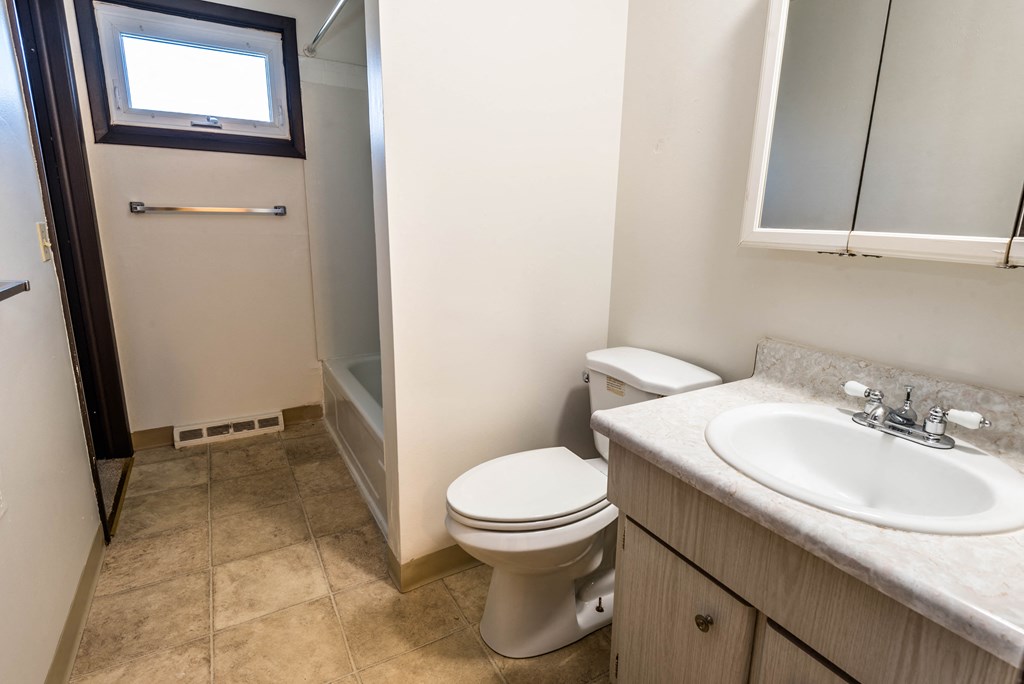 a bathroom with a toilet and a sink and a shower