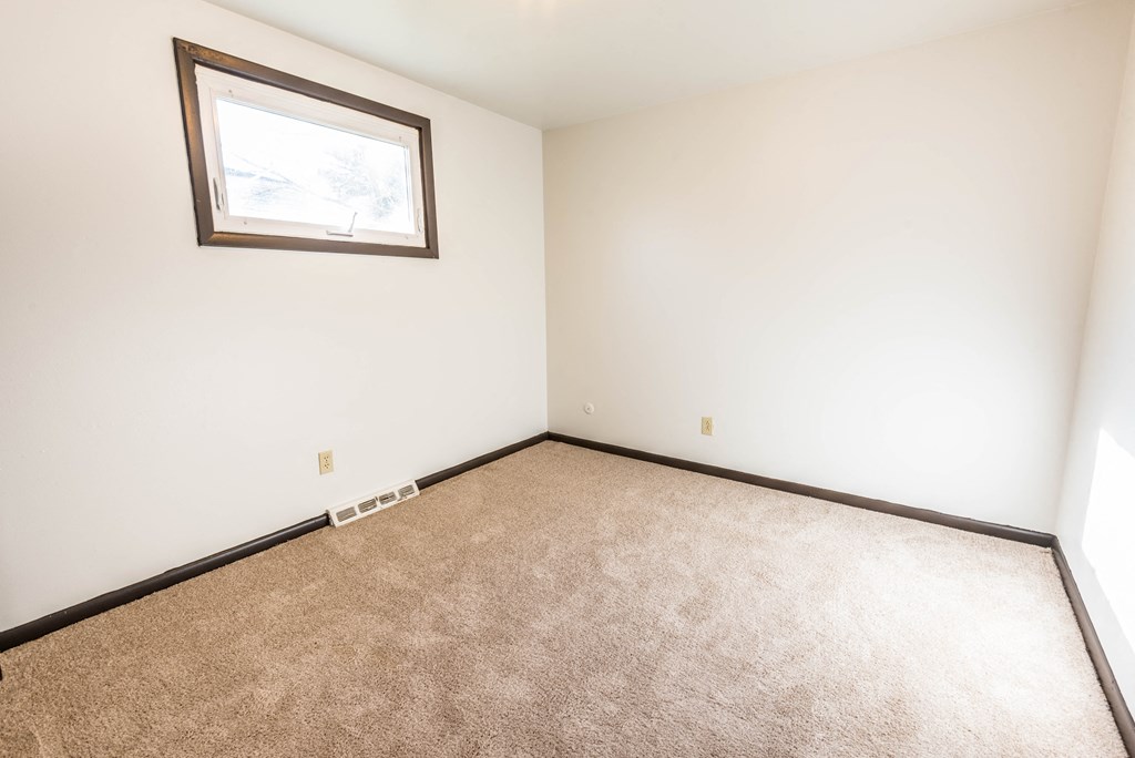 a empty room with carpet and a window