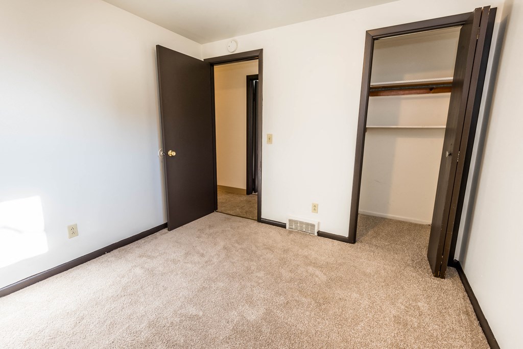 an empty room with two closets and a door to a closet