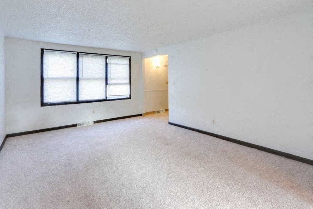 an empty room with a window and a white wall
