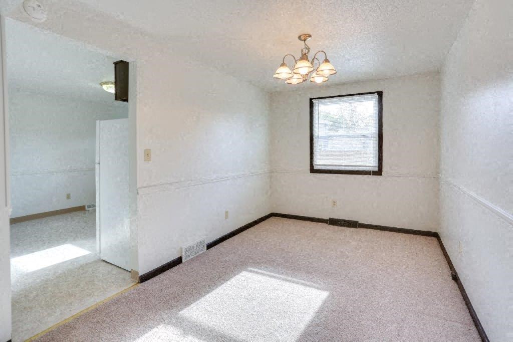 an empty living room with a window and a ceiling fan