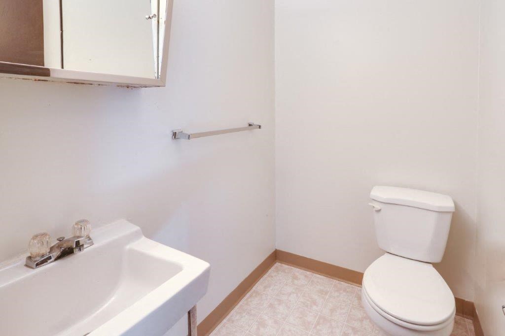 a bathroom with a toilet and a sink and a mirror