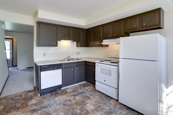 A kitchen with a white refrigerator, black dishwasher, and white oven.