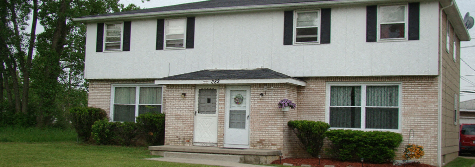 a white and brick house with a white door and windows