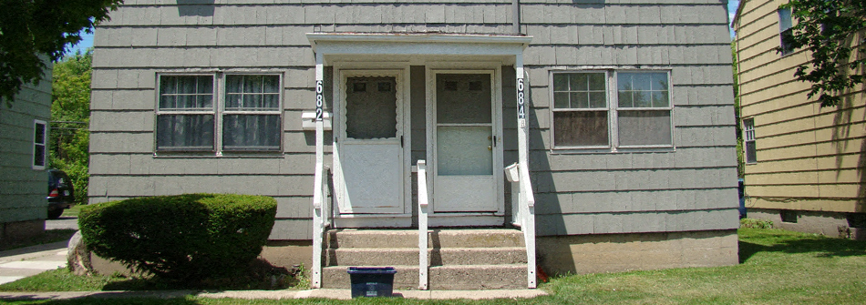 the front of a house with steps and a blue door