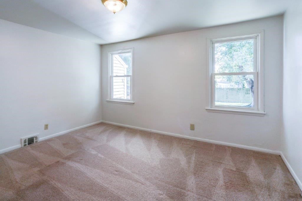 an empty room with white walls and a window