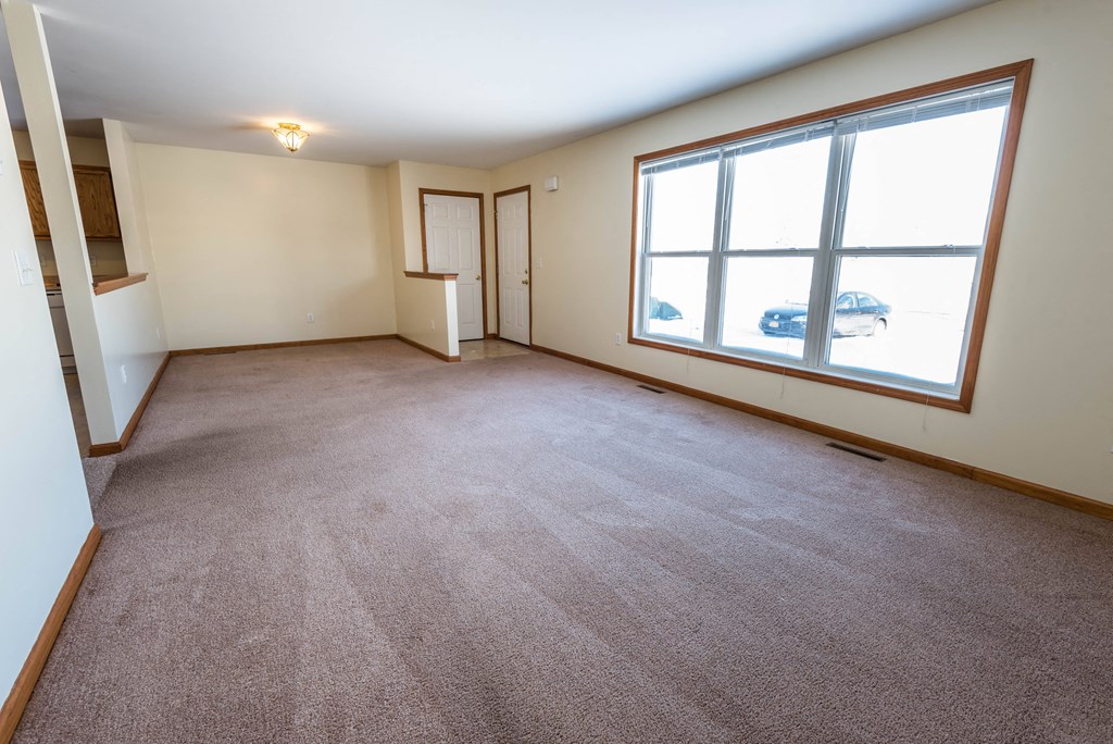 the living room of an empty home with a large window