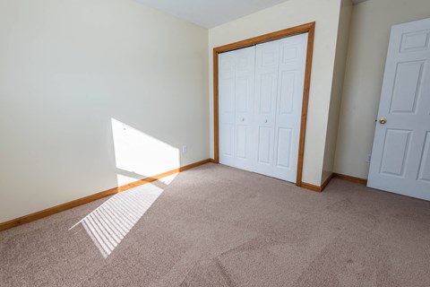 a bedroom with a carpeted floor and a white door