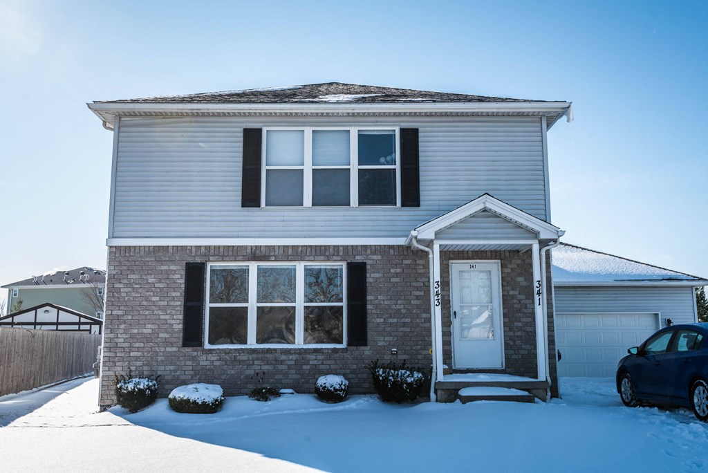 a house covered in snow on a sunny day