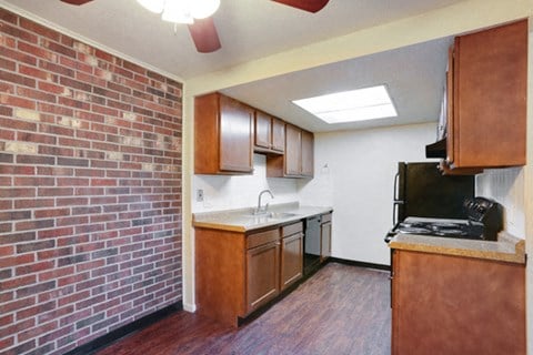 a kitchen with a brick wall and a stove and a sink