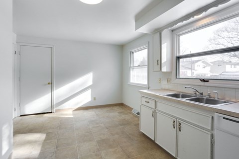 A kitchen with white cabinets and a sink.