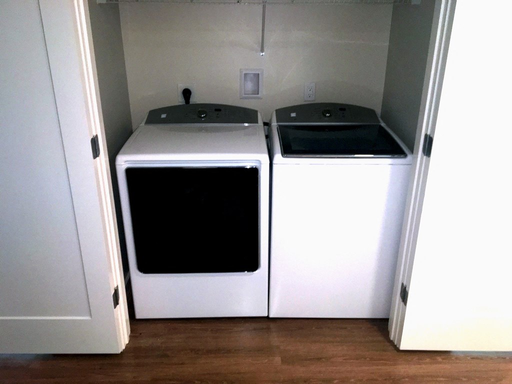two washers and dryers in a room with a door