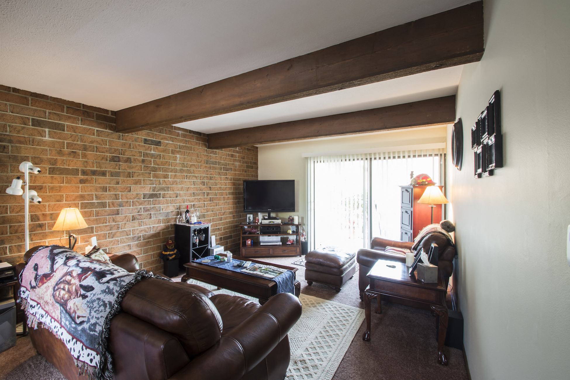 a living room with a leather couch and a tv