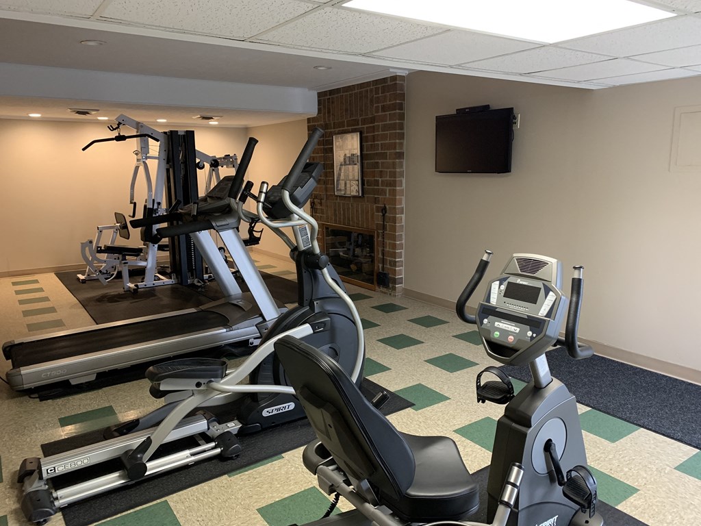 a gym with exercise equipment and a tv