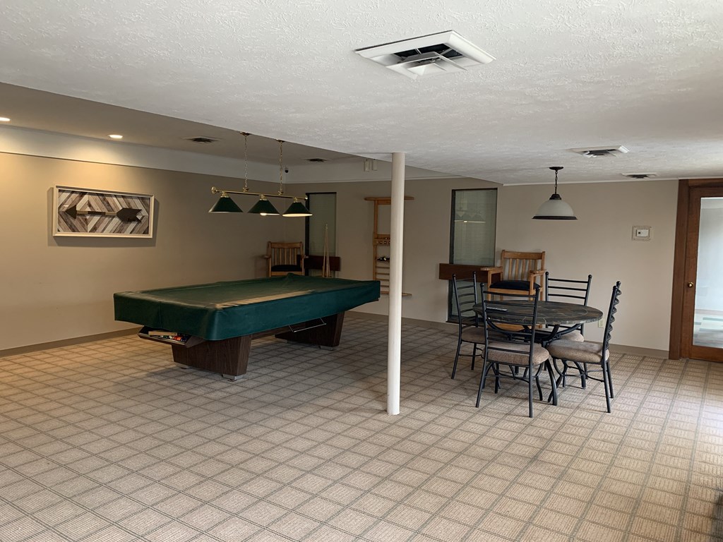 a game room with a pool table and a dining table