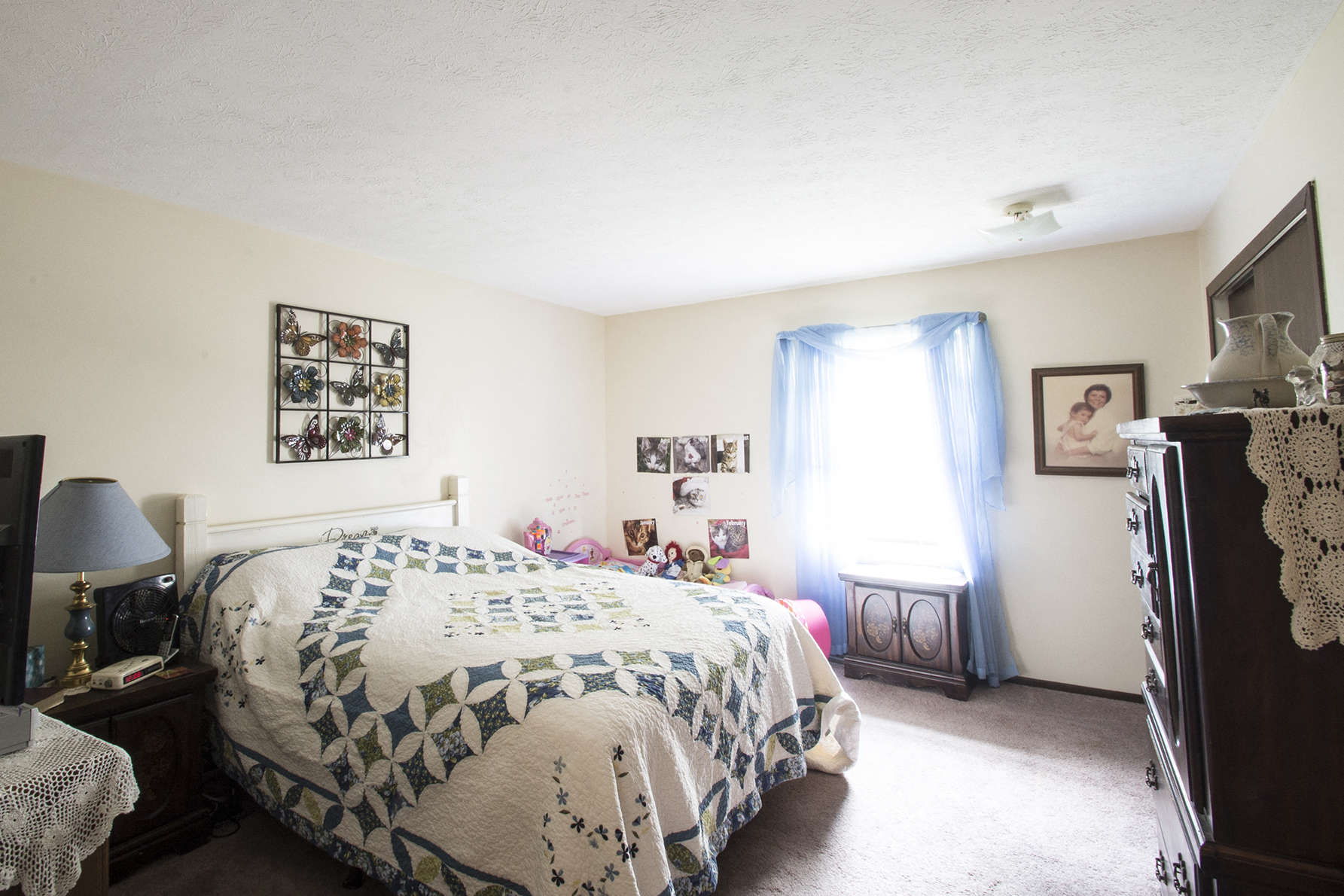 a bedroom with a bed and a dresser and a window
