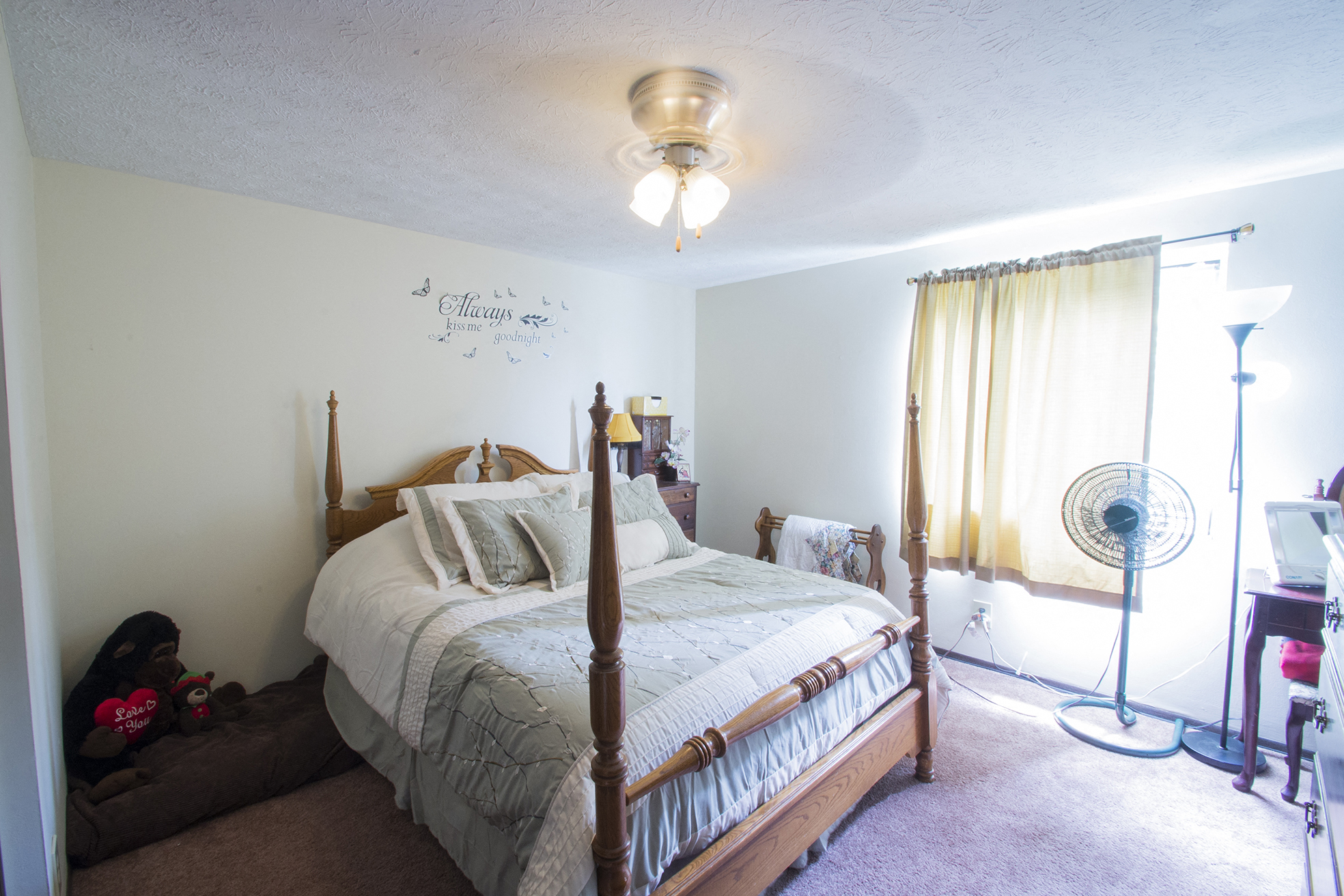 a bedroom with a bed and a fan