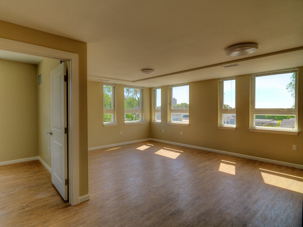 an empty living room with wood floors and windows