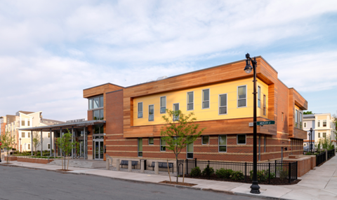 the building has a red brick facade and a yellow building with windows