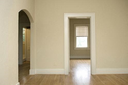 an empty living room with a door and a window