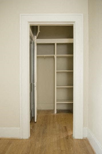 an empty room with a closet with shelves