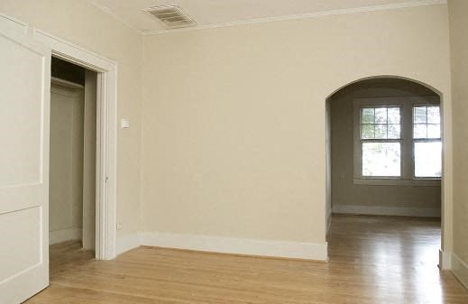 an empty room with a hard wood floor and a door