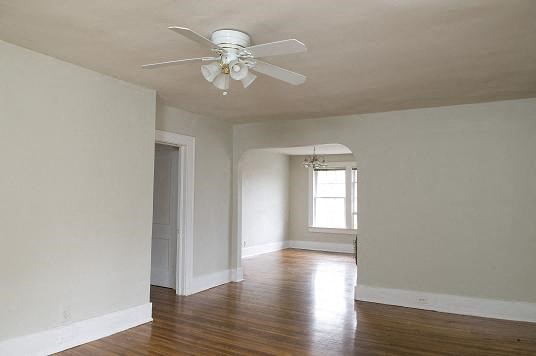 an empty living room with a ceiling fan