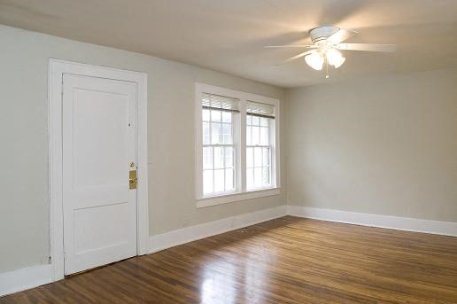 an empty room with a ceiling fan and a window